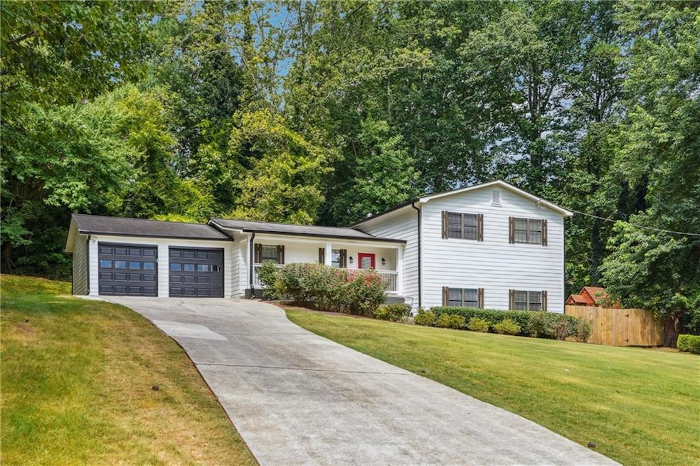 Tri-level home with driveway, an attached garage, and a porch