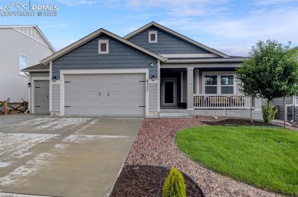 The 3 car garage, covered porch, and fresh sod gre