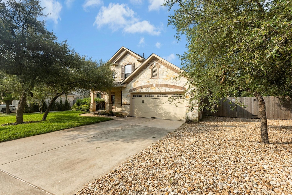 View of front of property featuring stone siding, concrete driveway, and a garage