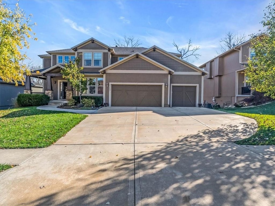 Craftsman house featuring a garage and a front lawn