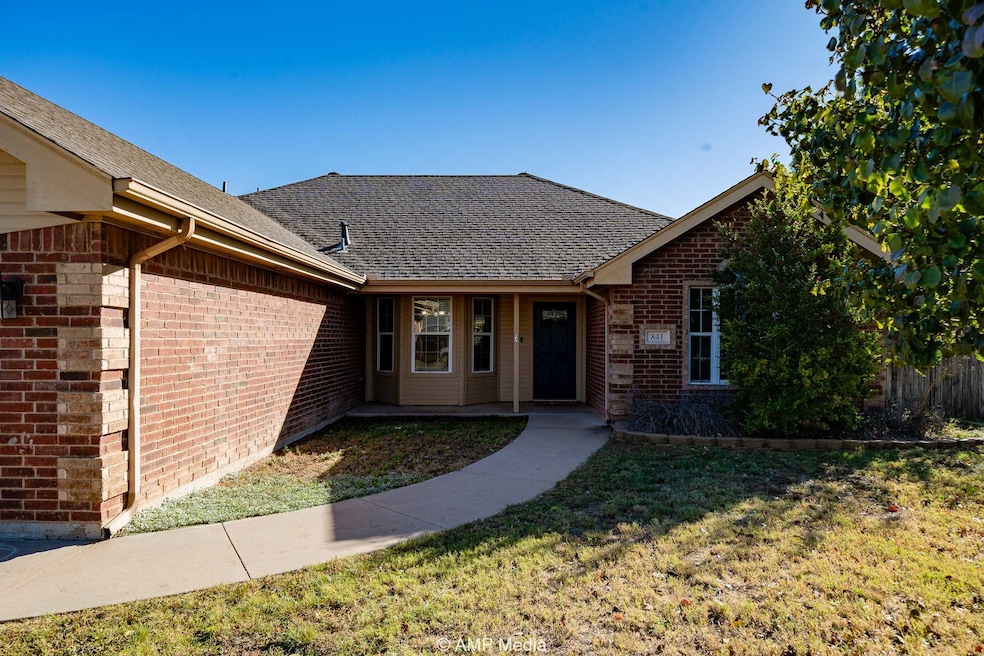 View of front of home with brick siding, a shingled roof, and a front yard