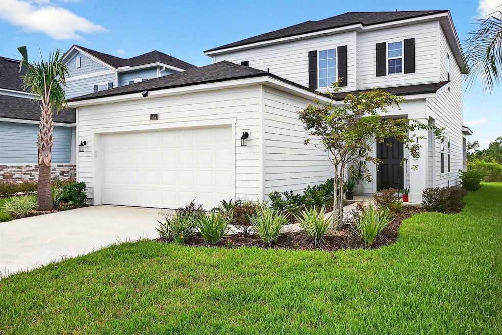 View of front of house featuring a front yard, driveway, a garage, and a shingled roof