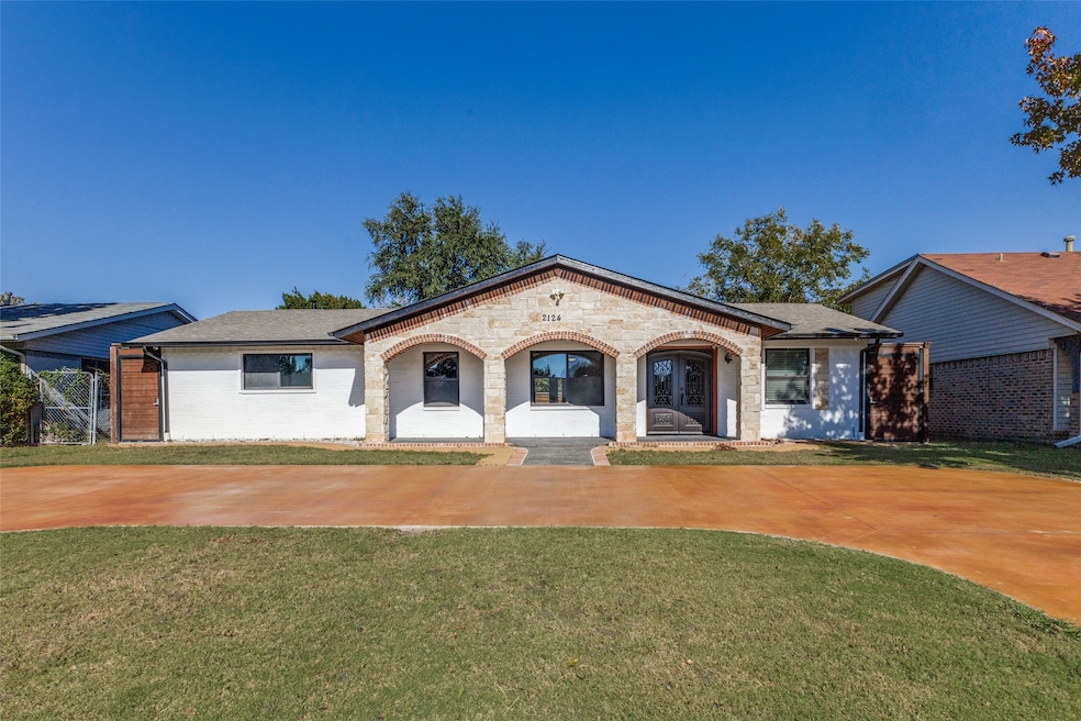 Mediterranean / spanish house featuring covered porch, a front yard, brick siding, and stone siding