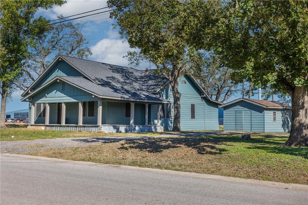 View of front of property featuring a porch, a front lawn, and roof with shingles