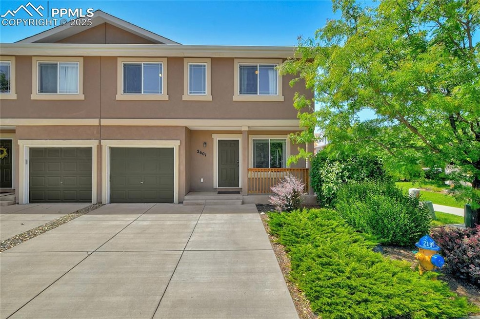 View of property featuring stucco siding, driveway, and a garage