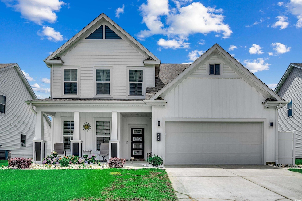 View of front facade featuring board and batten siding, a shingled roof, a garage, concrete driveway, and covered porch