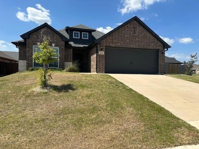 View of front of house with a front lawn and a garage