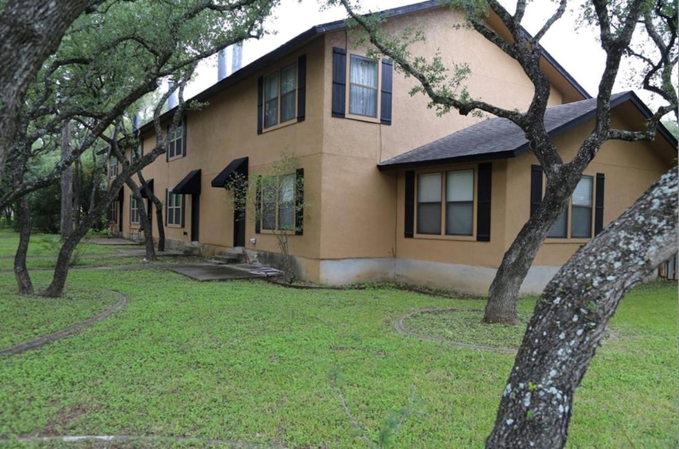 View of home's exterior featuring stucco siding, a lawn, and roof with shingles