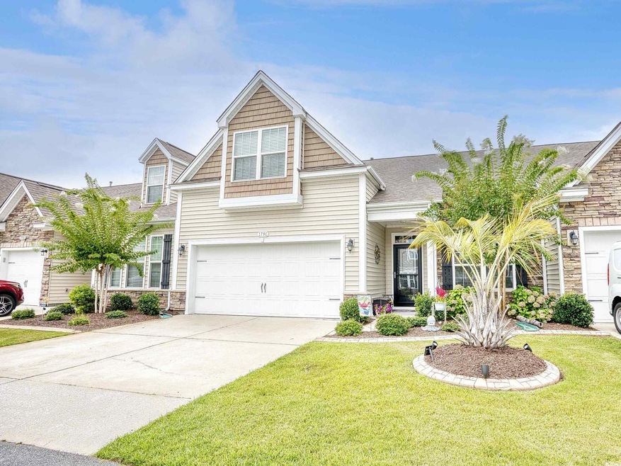 View of front of house with a garage and a front y