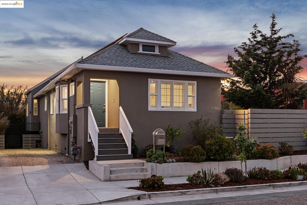 Bungalow with a shingled roof and stucco siding