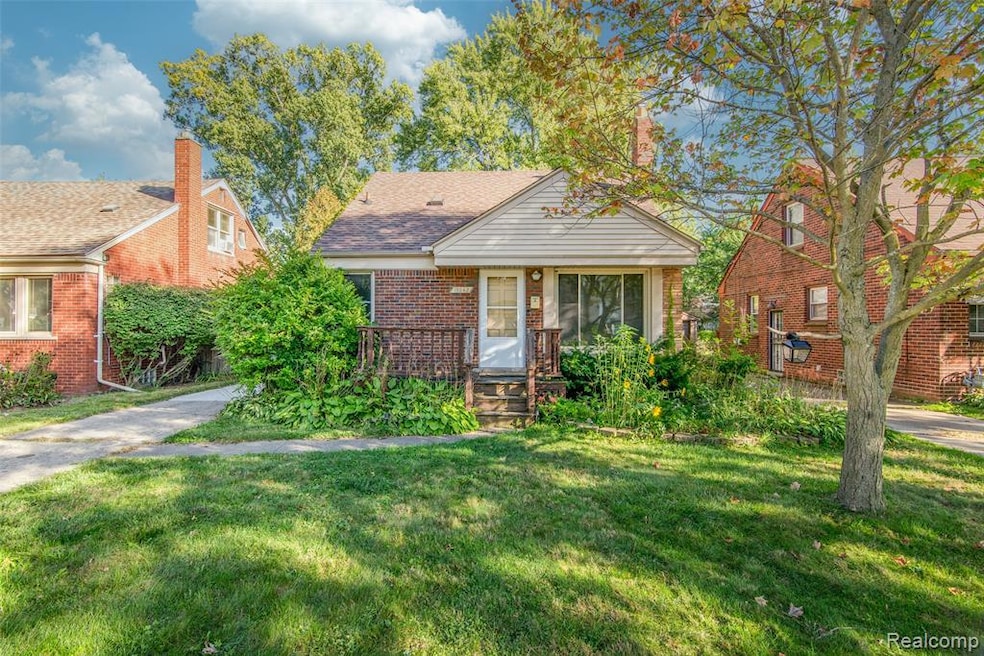 Bungalow-style house with brick siding, a front yard, a chimney, and roof with shingles
