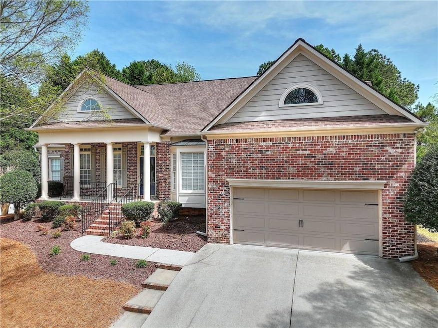Neoclassical home featuring a garage, driveway, br