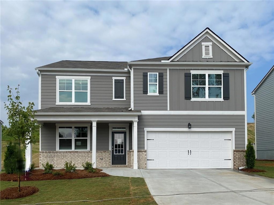 Craftsman-style home featuring concrete driveway, an attached garage, board and batten siding, a front lawn, and covered porch