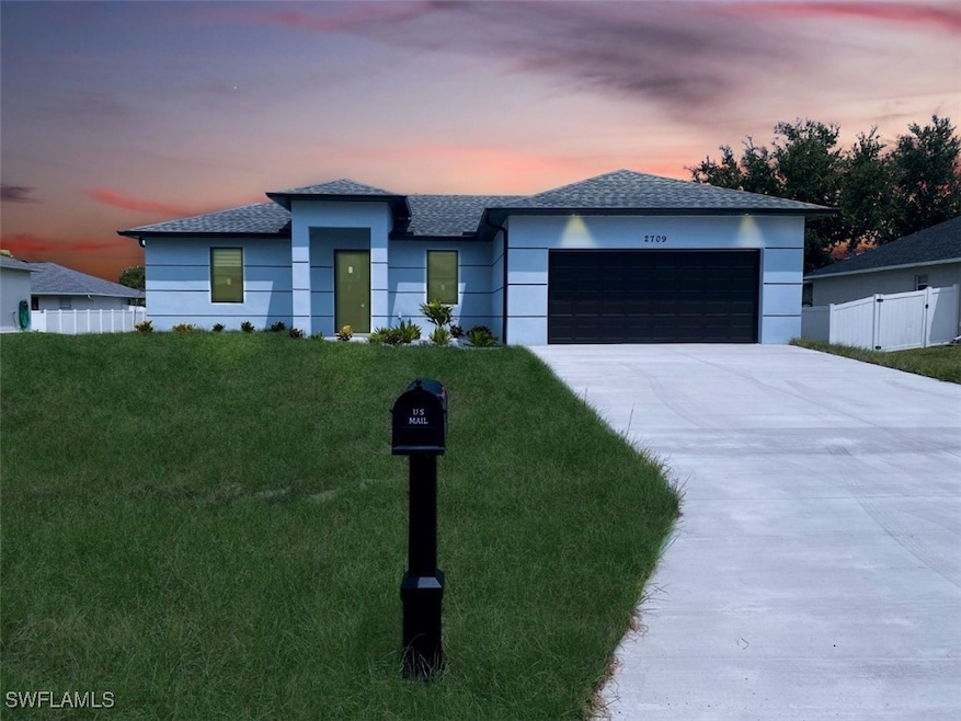 View of front of home featuring a garage and a law