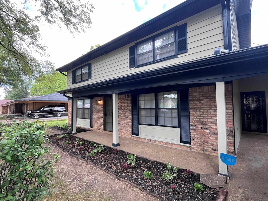 View of side of home with brick siding and a porch