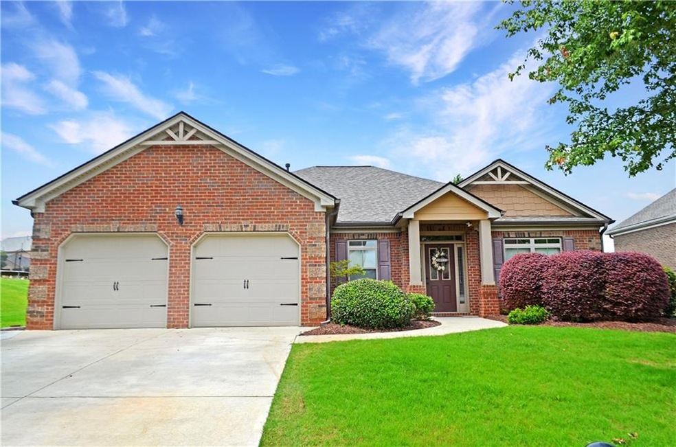 Craftsman house with brick siding, a garage, concrete driveway, and a front yard