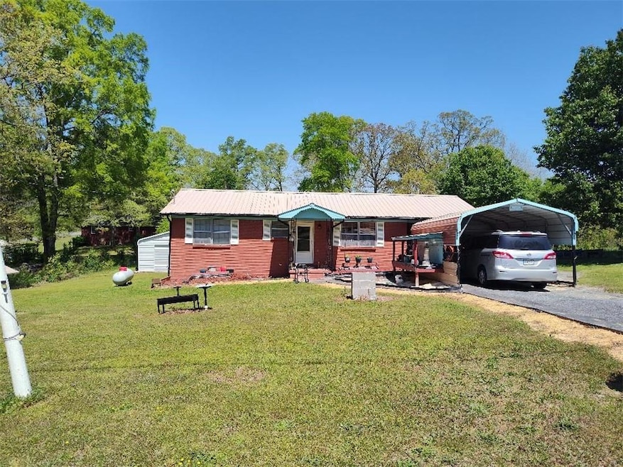 Ranch-style home with a front yard, metal roof, dr
