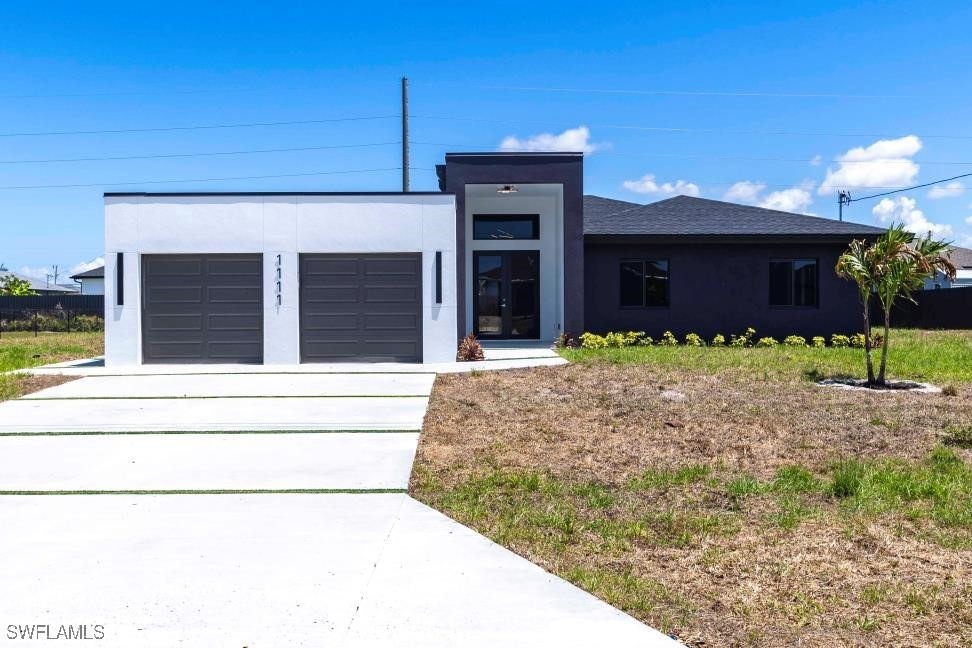 View of front facade with stucco siding, driveway,