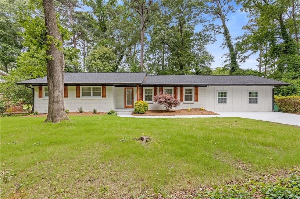 Ranch-style home with board and batten siding, a front lawn, brick siding, and driveway