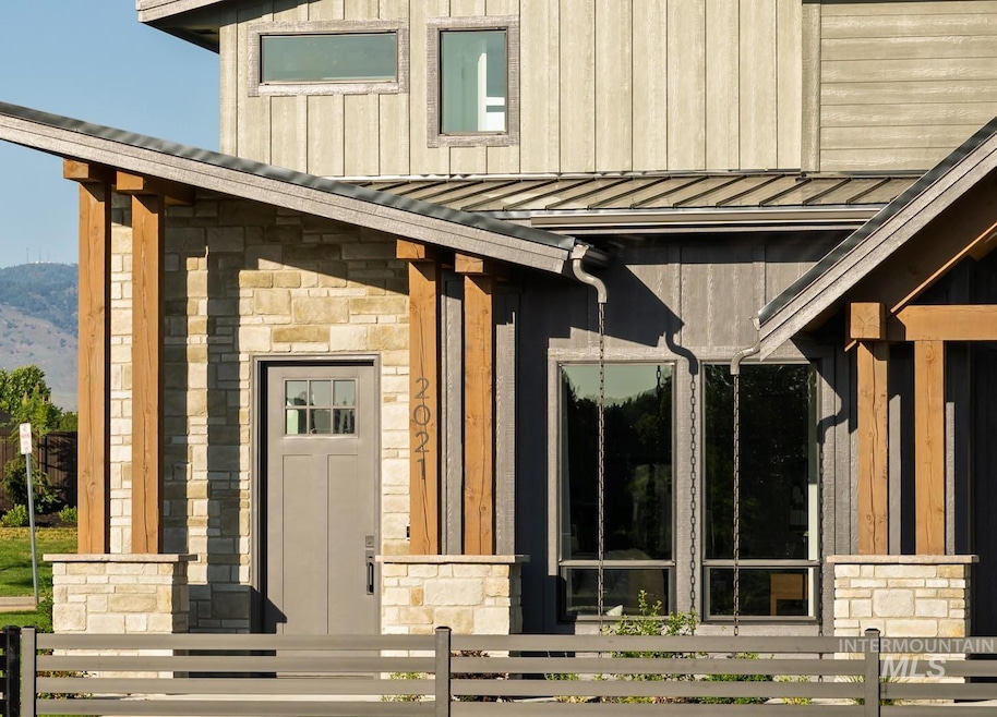 View of exterior entry with a standing seam roof, stone siding, a metal roof, and board and batten siding