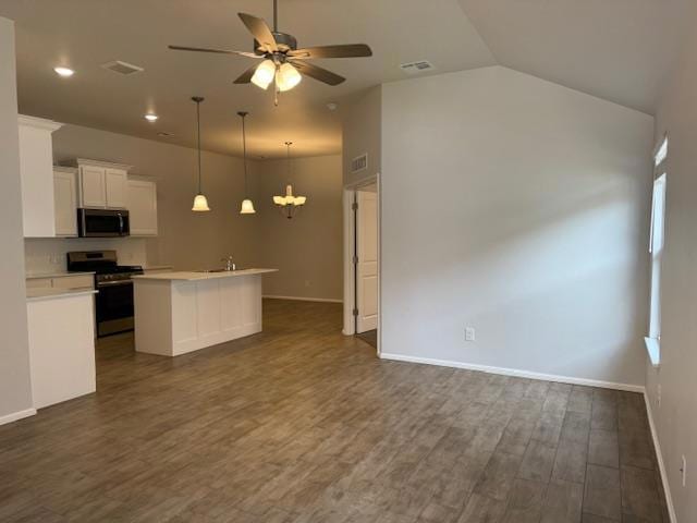 Kitchen with a center island with sink, appliances with stainless steel finishes, white cabinetry, dark wood-style floors, and ceiling fan