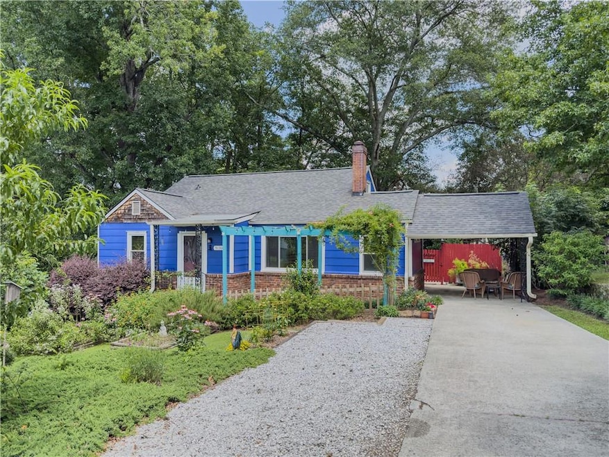 Ranch-style home with concrete driveway, a chimney, a shingled roof, and a carport