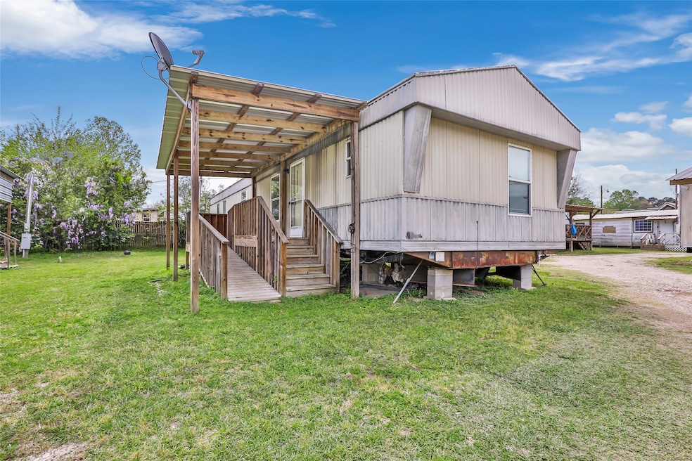 This photo shows a mobile home with a wooden porch