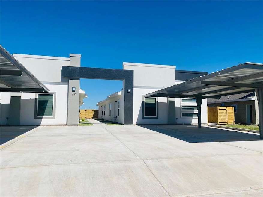 View of front facade with stucco siding and covered parking