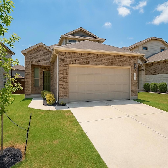 View of front facade with a garage, brick siding,