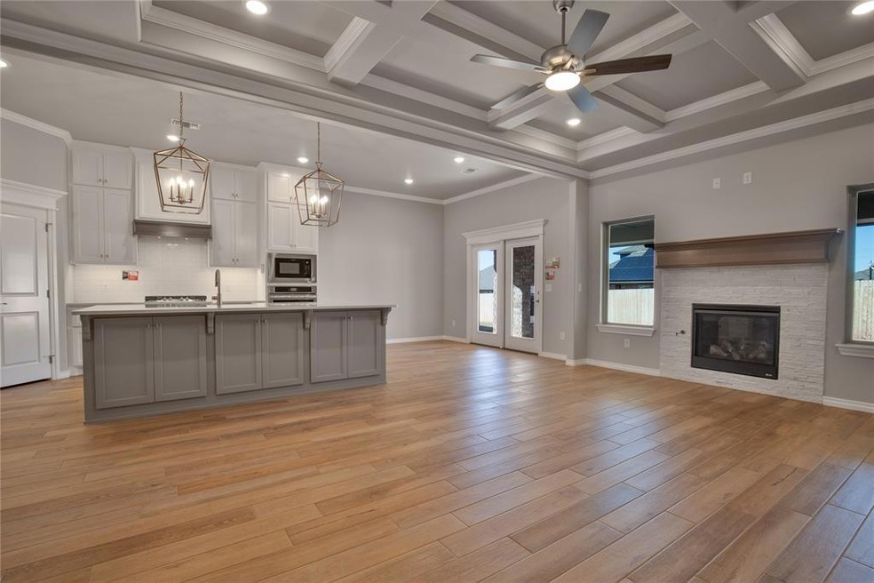 Kitchen featuring an island with sink, light hardw