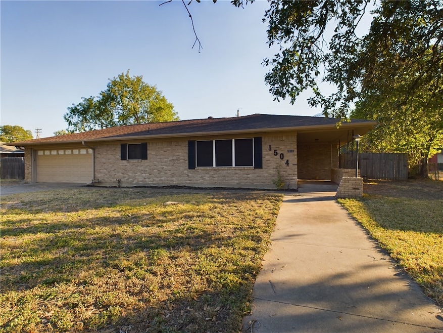 Ranch-style house featuring driveway, brick siding, and an attached garage