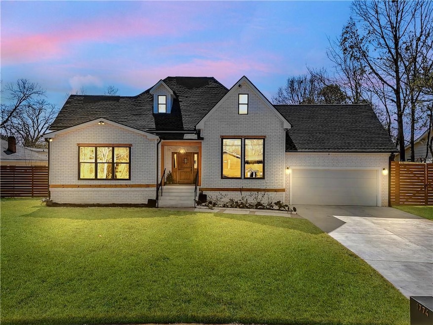 View of front facade with brick siding, a garage, driveway, and a shingled roof