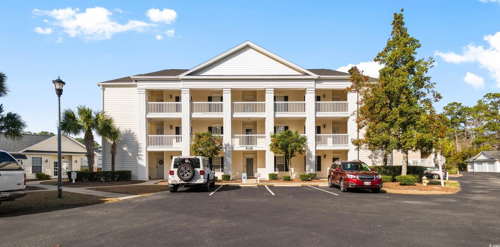 View of building exterior with uncovered parking