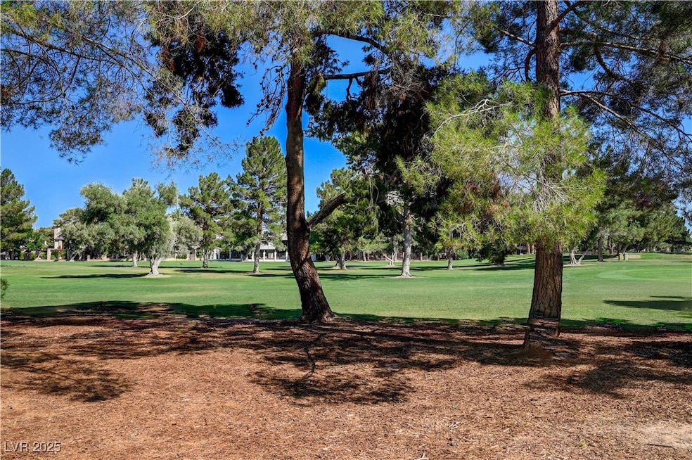 View of community featuring a lawn and view of woo