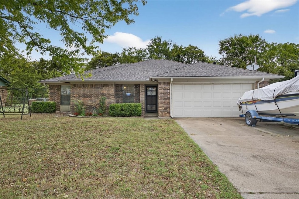 Ranch-style house with brick siding, a shingled roof, a front yard, driveway, and a garage
