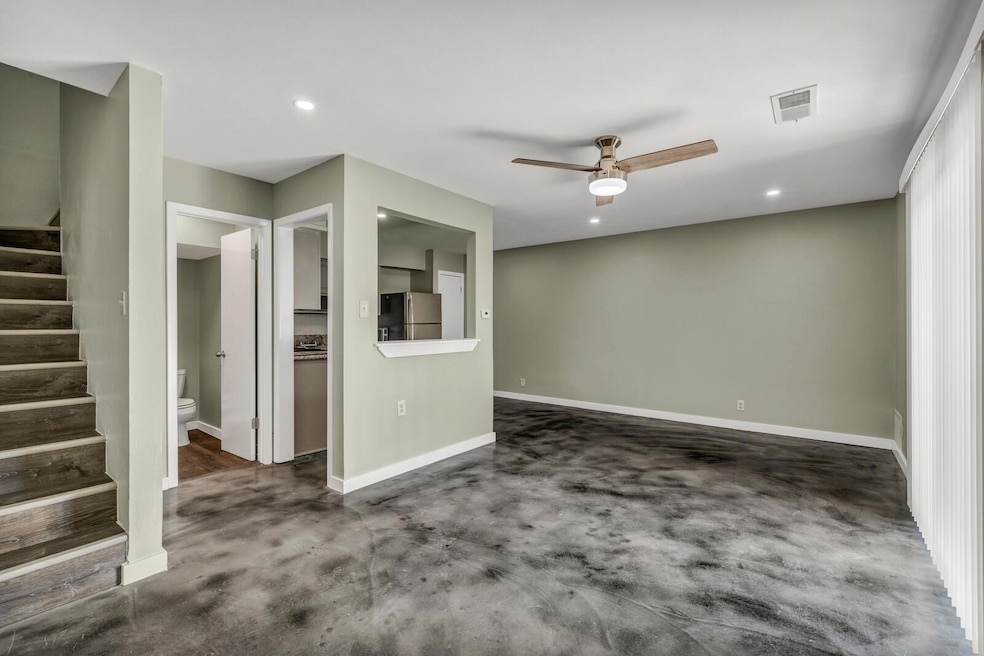 Spare room with ceiling fan, stairs, baseboards, 