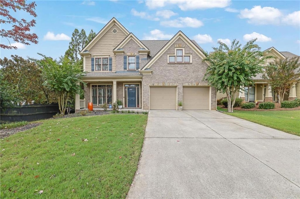 Craftsman-style house featuring a front yard, brick siding, driveway, and covered porch