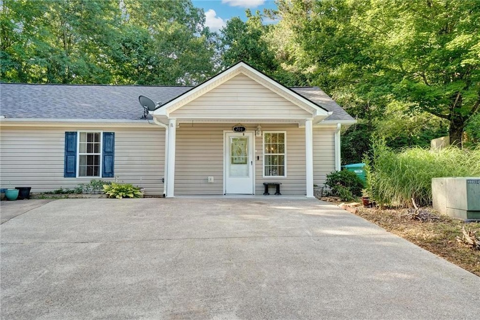 Single story home featuring roof with shingles, concrete driveway, and a porch