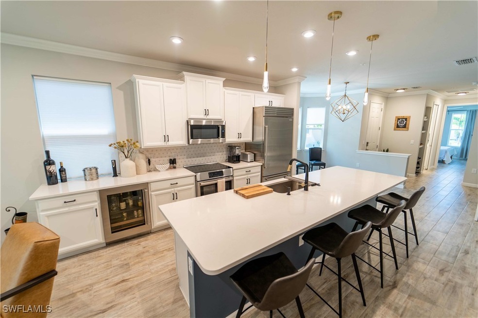 Kitchen with sink, hanging light fixtures, an isla