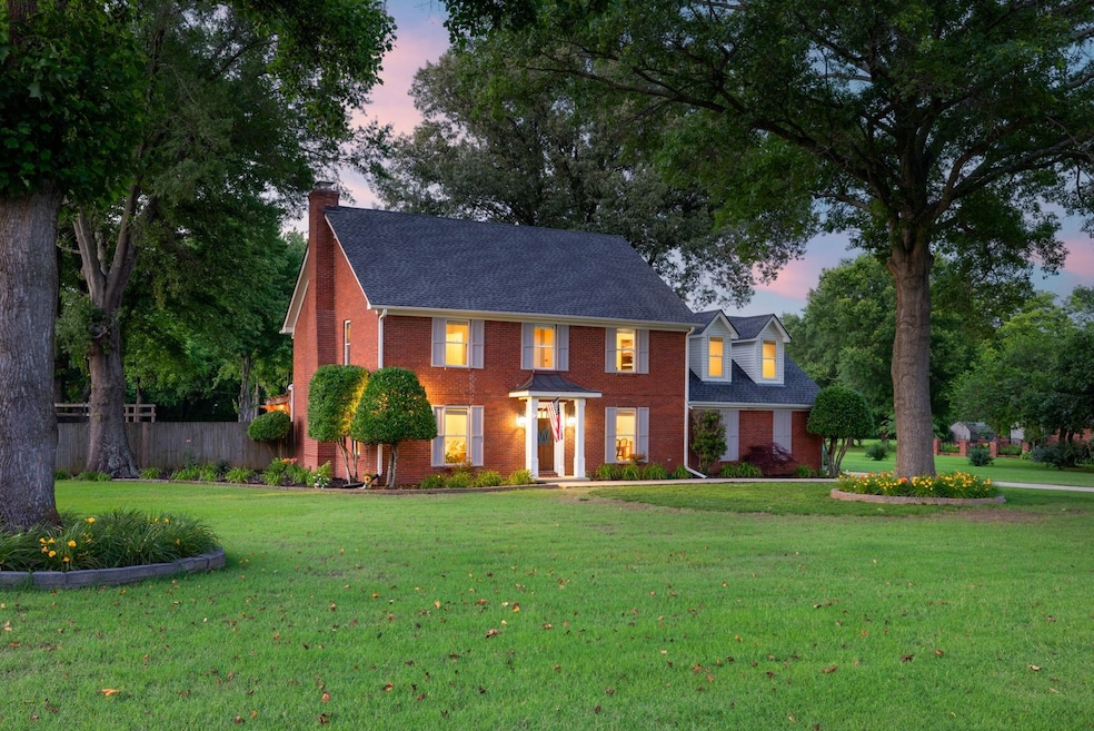 Colonial home with brick siding, a chimney, and roof with shingles