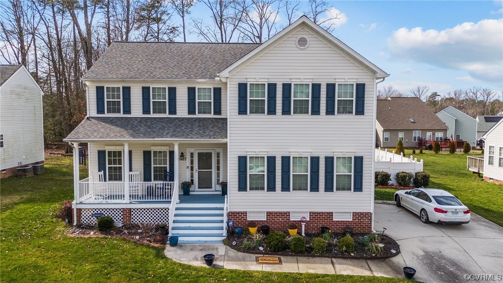 View of front of home with a porch, a front lawn, and central AC