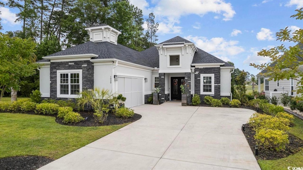 View of front facade with stone siding, an attached garage, concrete driveway, stucco siding, and a front lawn