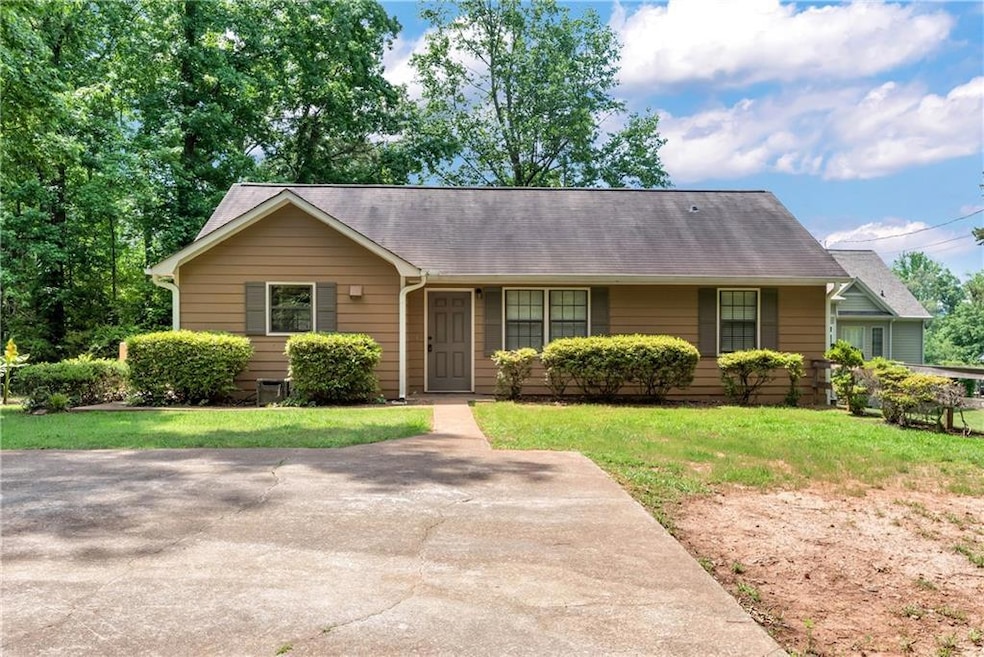 Ranch-style home with a front lawn and a shingled roof