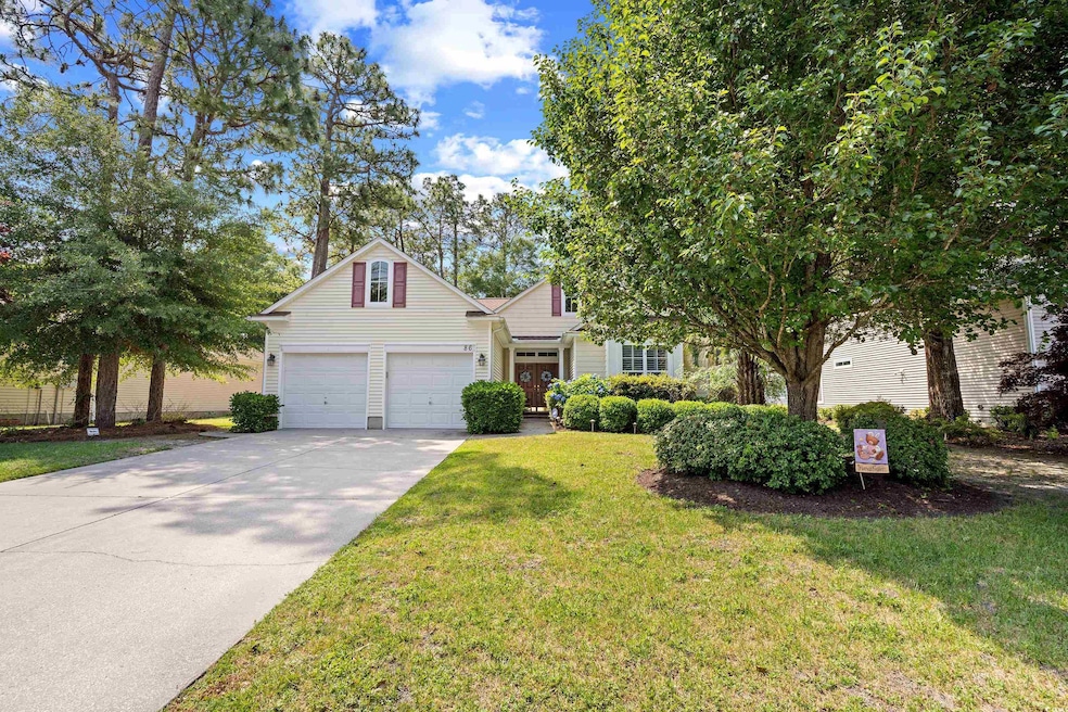 View of front of home featuring driveway, a garage, and a front lawn