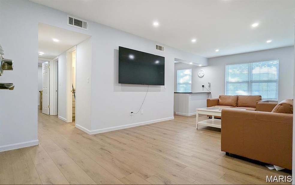 Living room featuring light wood-type flooring and recessed lighting