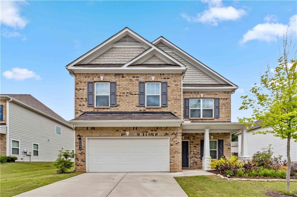 Craftsman-style home featuring brick siding, concrete driveway, a front lawn, and a garage