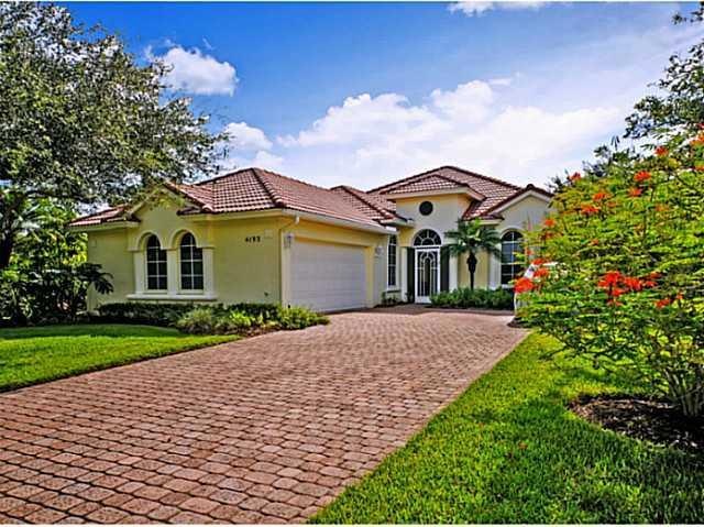 Exterior Front. Looking south from patio is the 2nd hole on Eagle Marsh over the lake This lot is extremely large for Jensen Beach Country Club  Nice landscaping with large oaks and palms