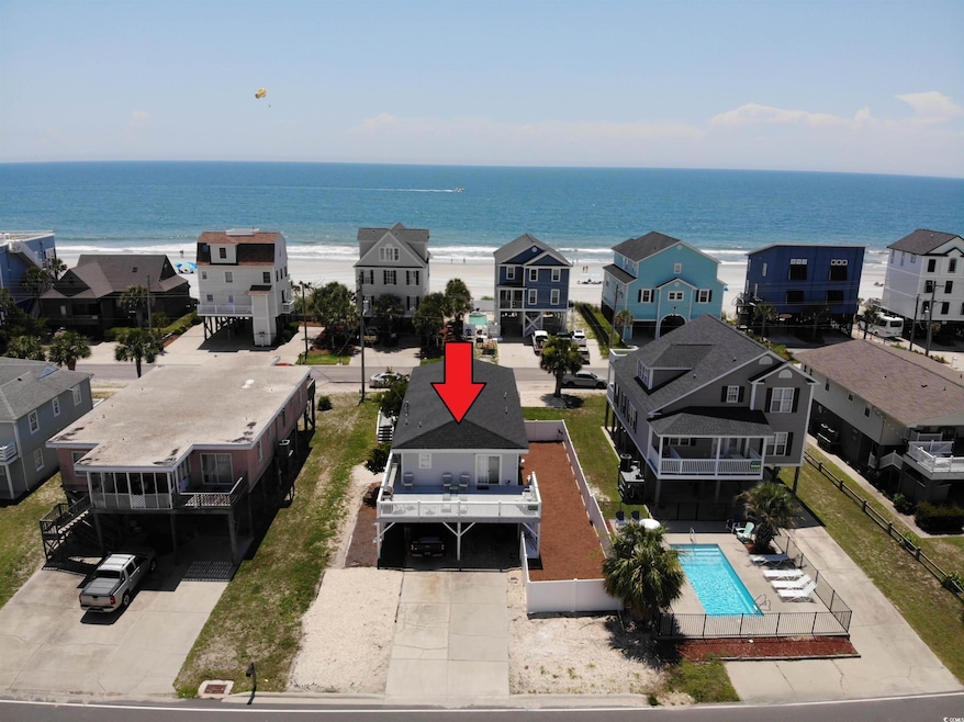 Aerial view of residential area featuring a pool and a nearby body of water