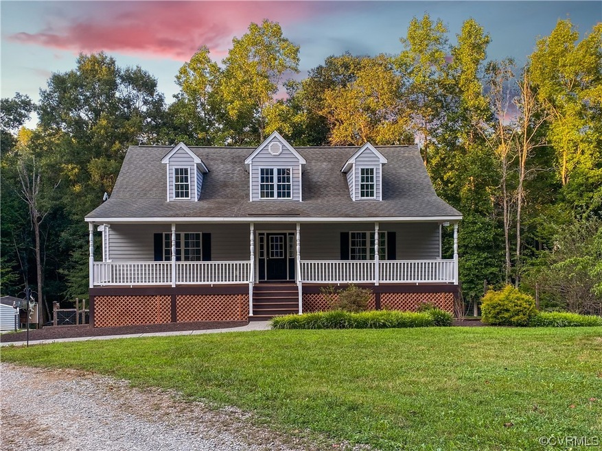 Cape cod house featuring a porch and a lawn