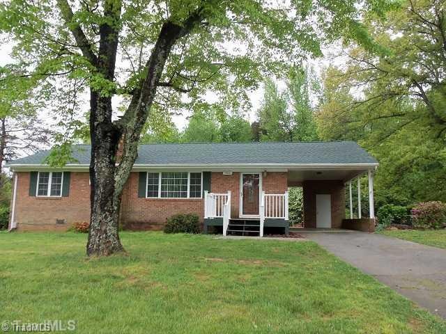 Exterior Front. Front of home shows a lovely yard, front porch, carport with storage, and a NEW ROOF!